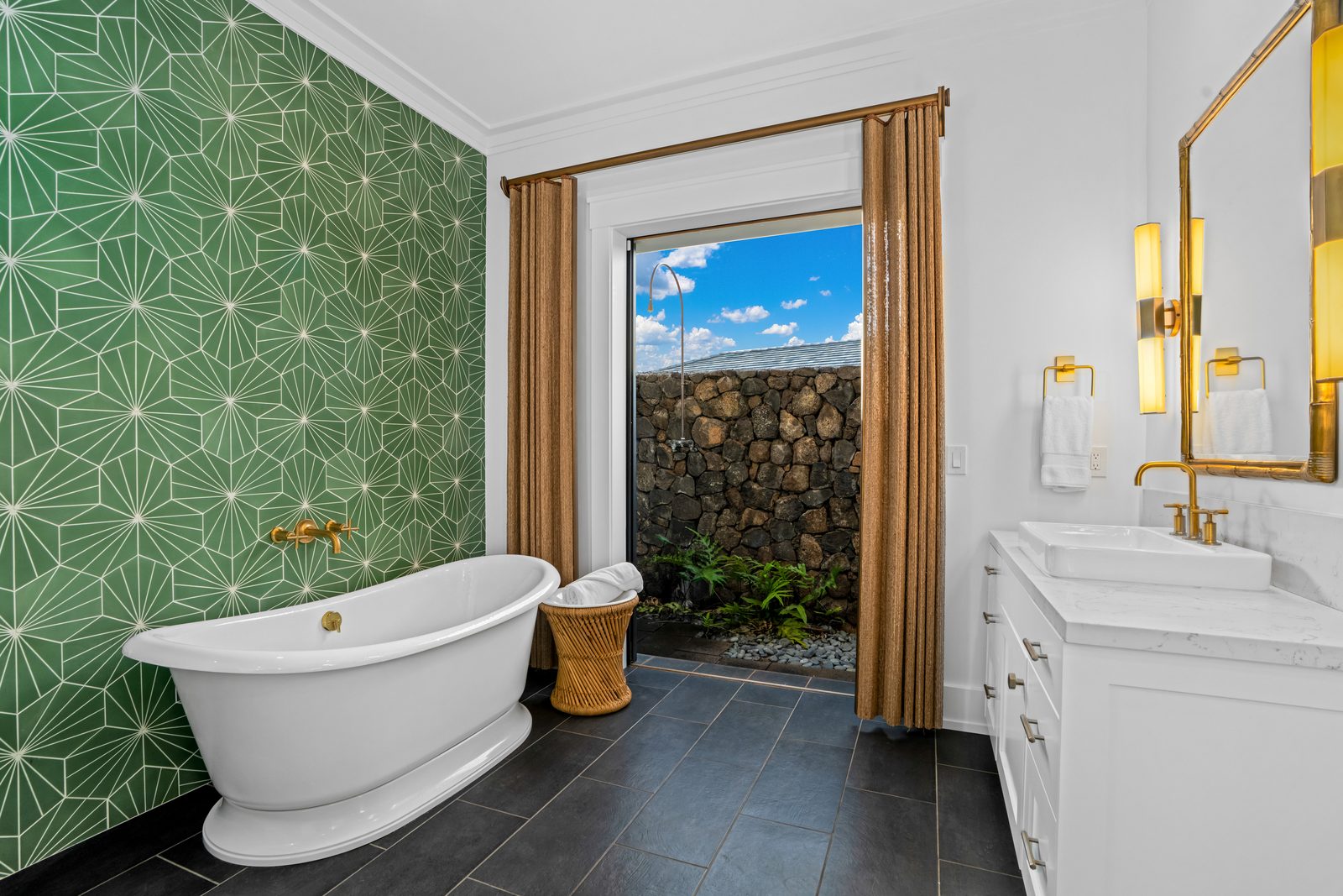The soaking tub beside the door out to a lava-rock outdoor shower