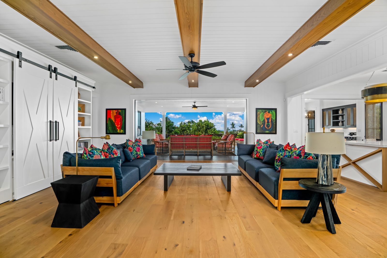 The great room with wood beams, open to the lanai beyond