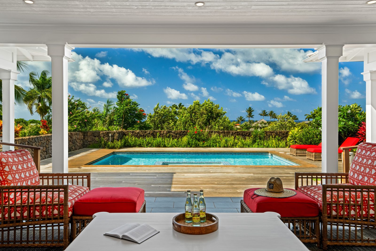 Looking out from the covered lanai through white columns to the pool