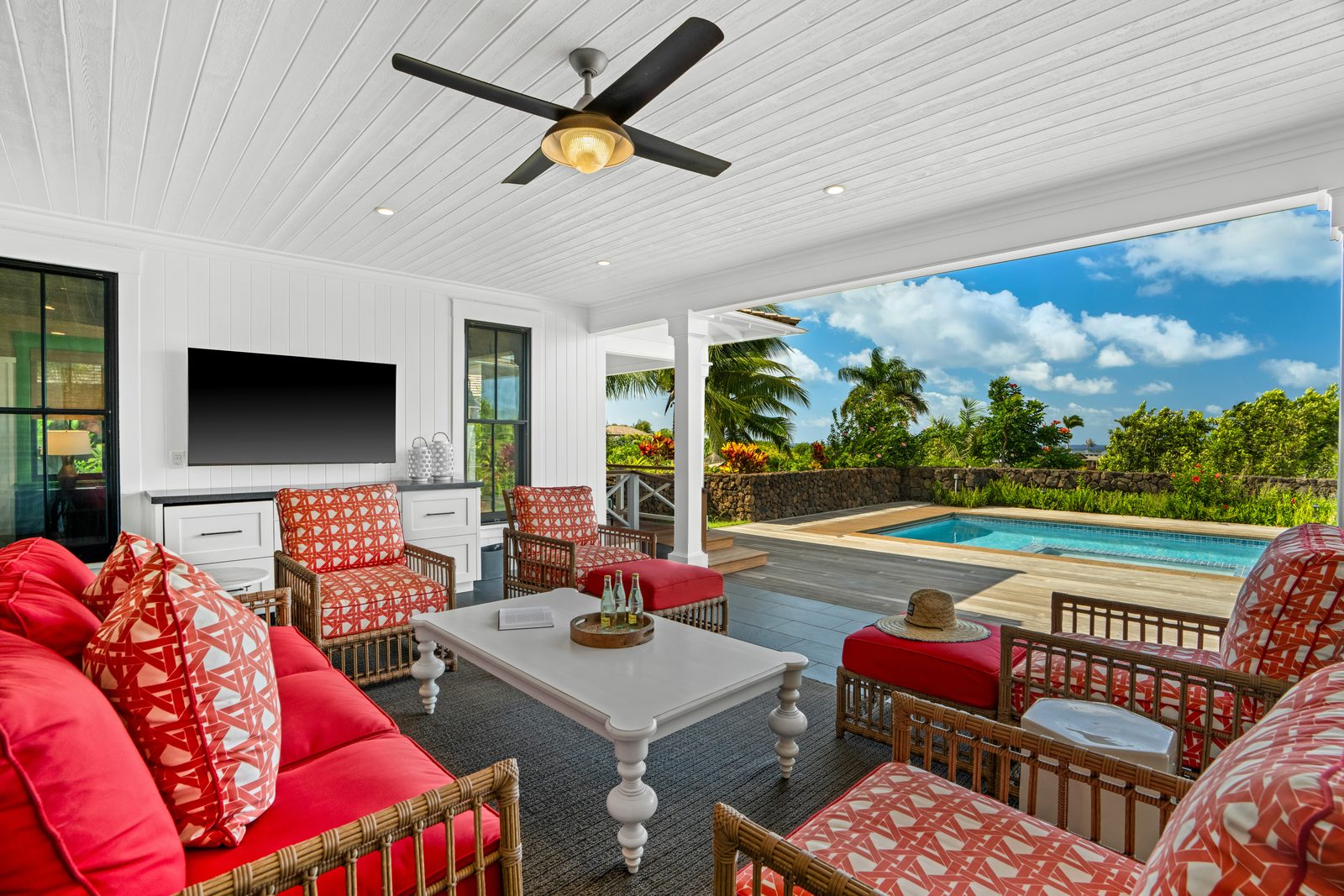 The lanai sitting room with its television and coral cushions