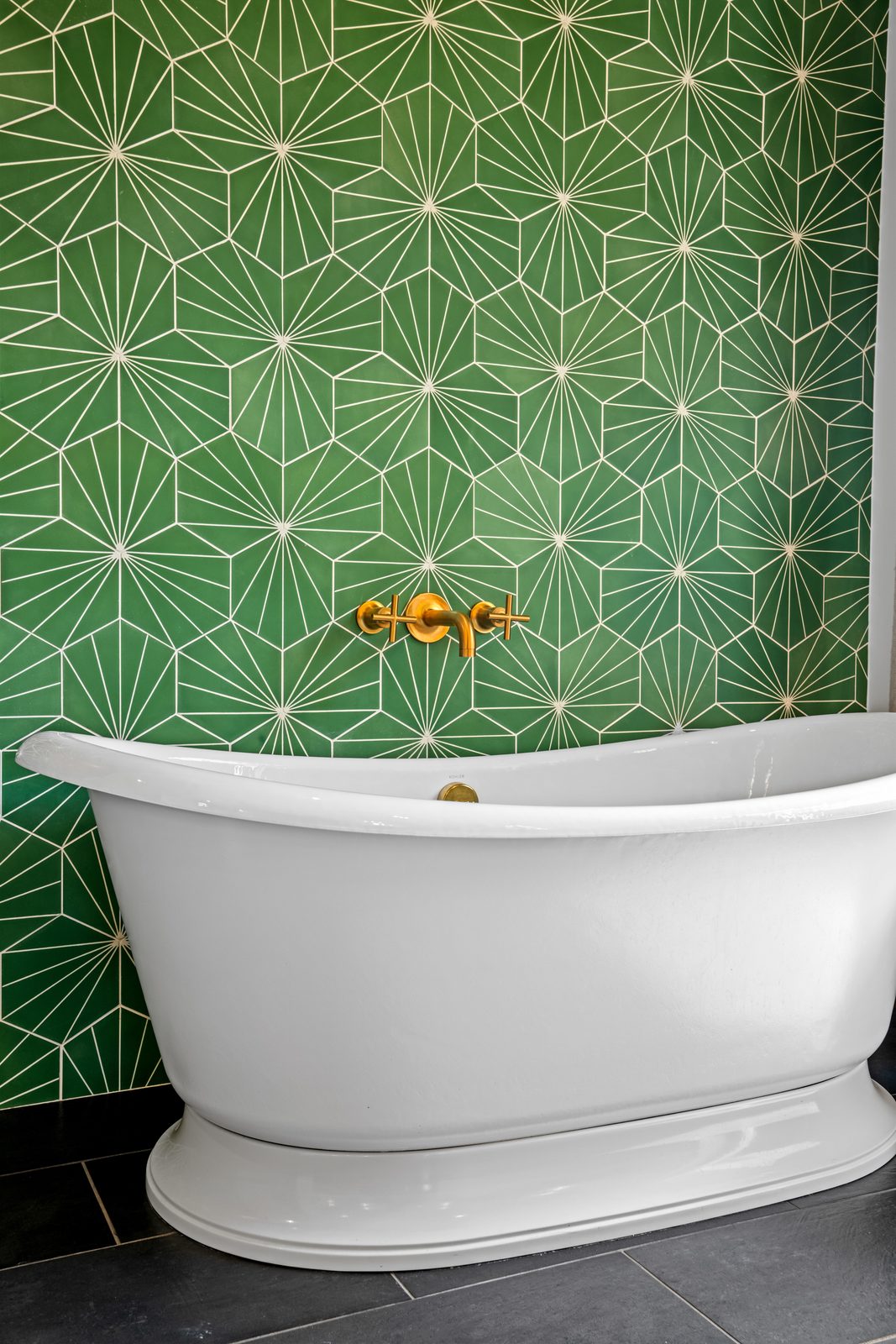 Outdoor shower behind the green tile wall, enclosed by lava rock
