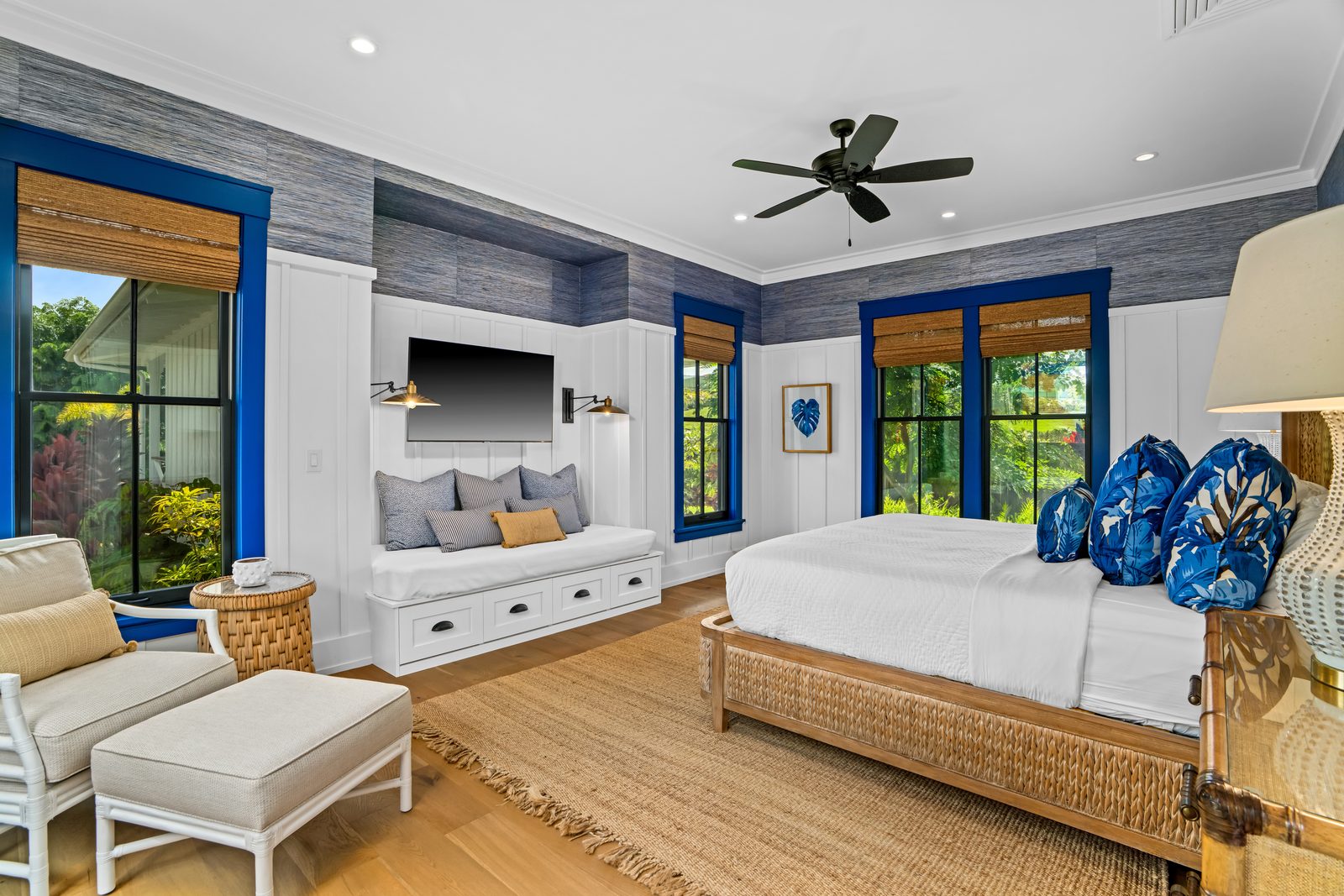 Built-in white day bed with cushions and drawers, beneath the television
