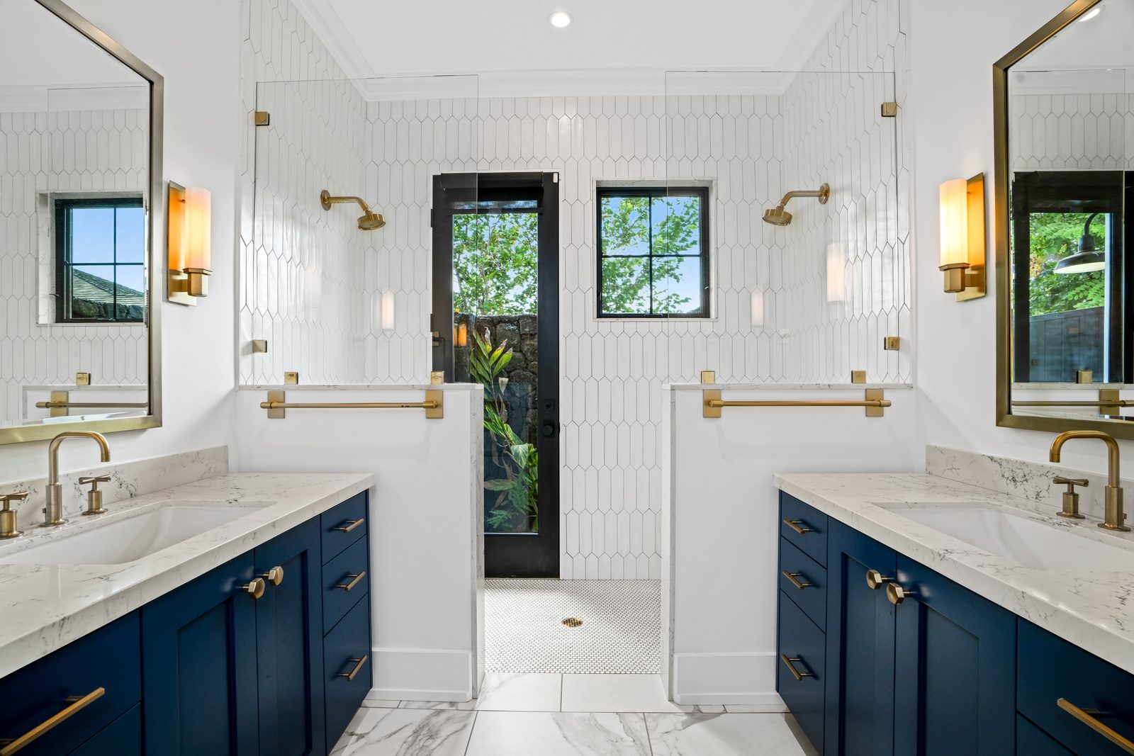 Blue Room bathroom with two navy vanities, brass fittings and a door out to the shower