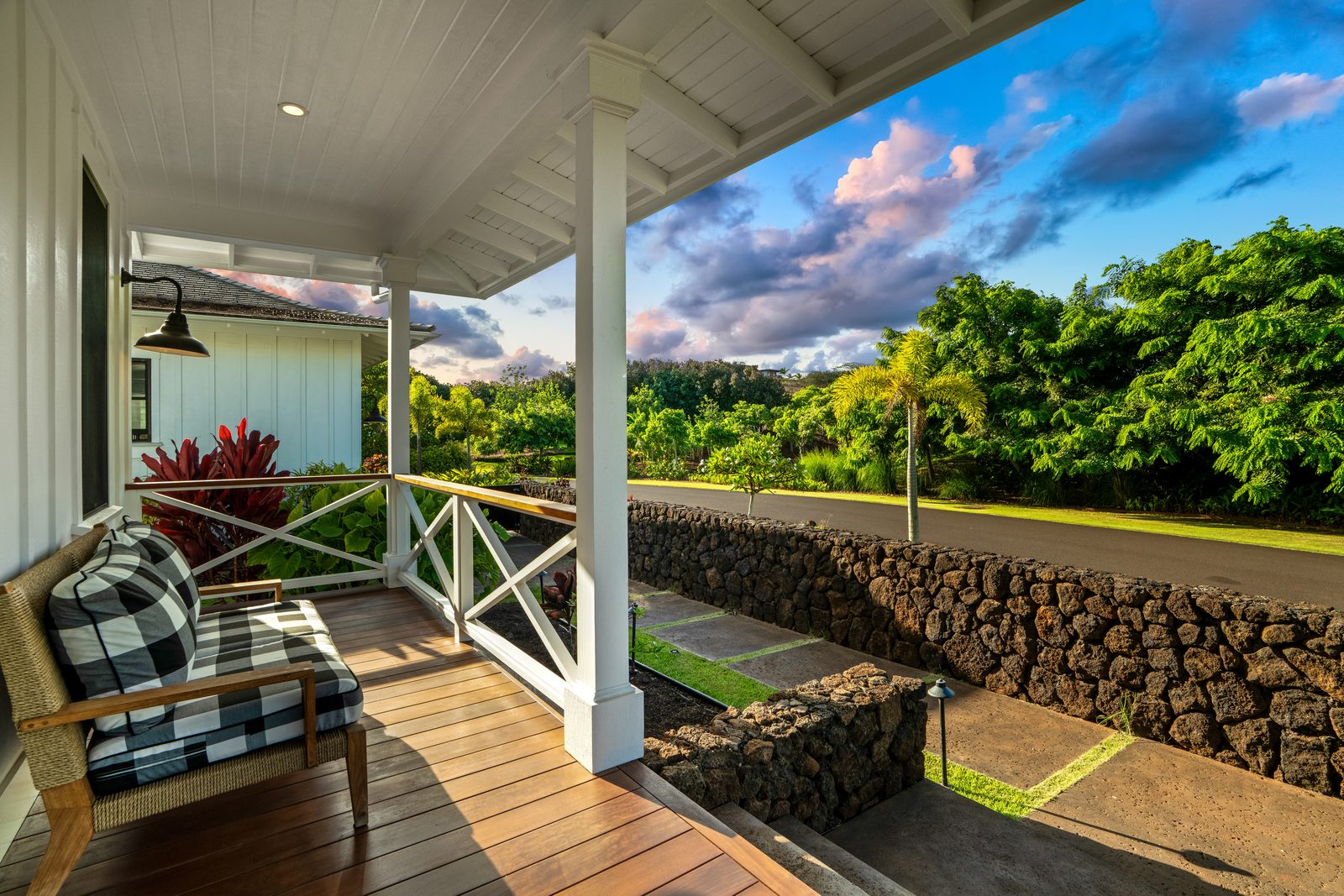 The front porch with cane chairs and a view to green hills