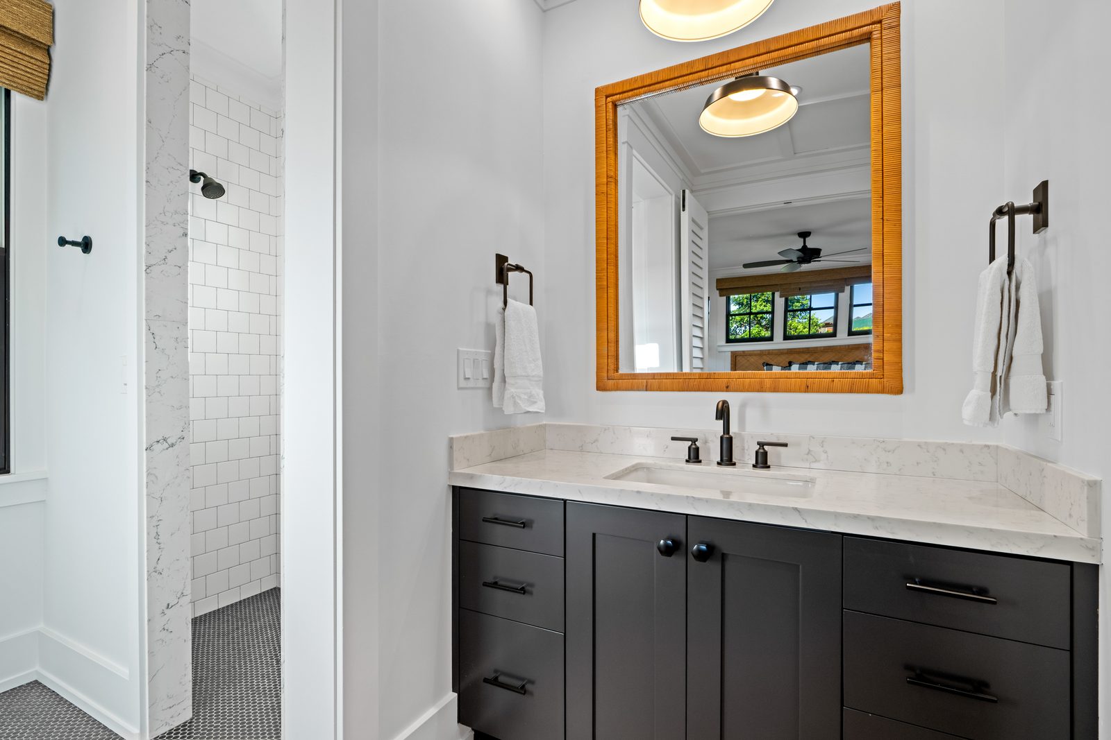 Ohana Unit bathroom with a dark vanity, oak-framed mirror and a walk-in shower