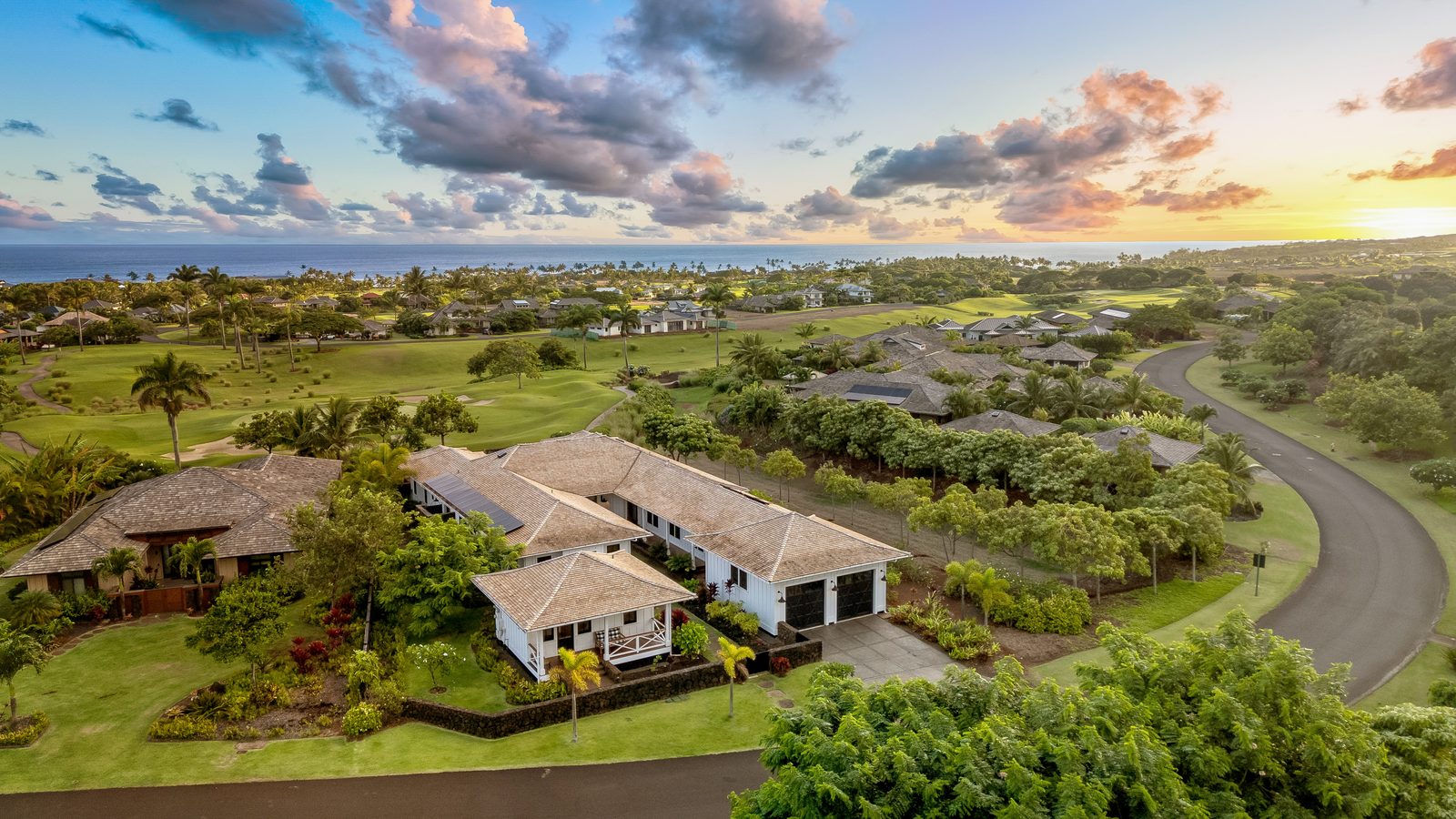 Aerial view over Kukui'ula at sunset with the ocean beyond