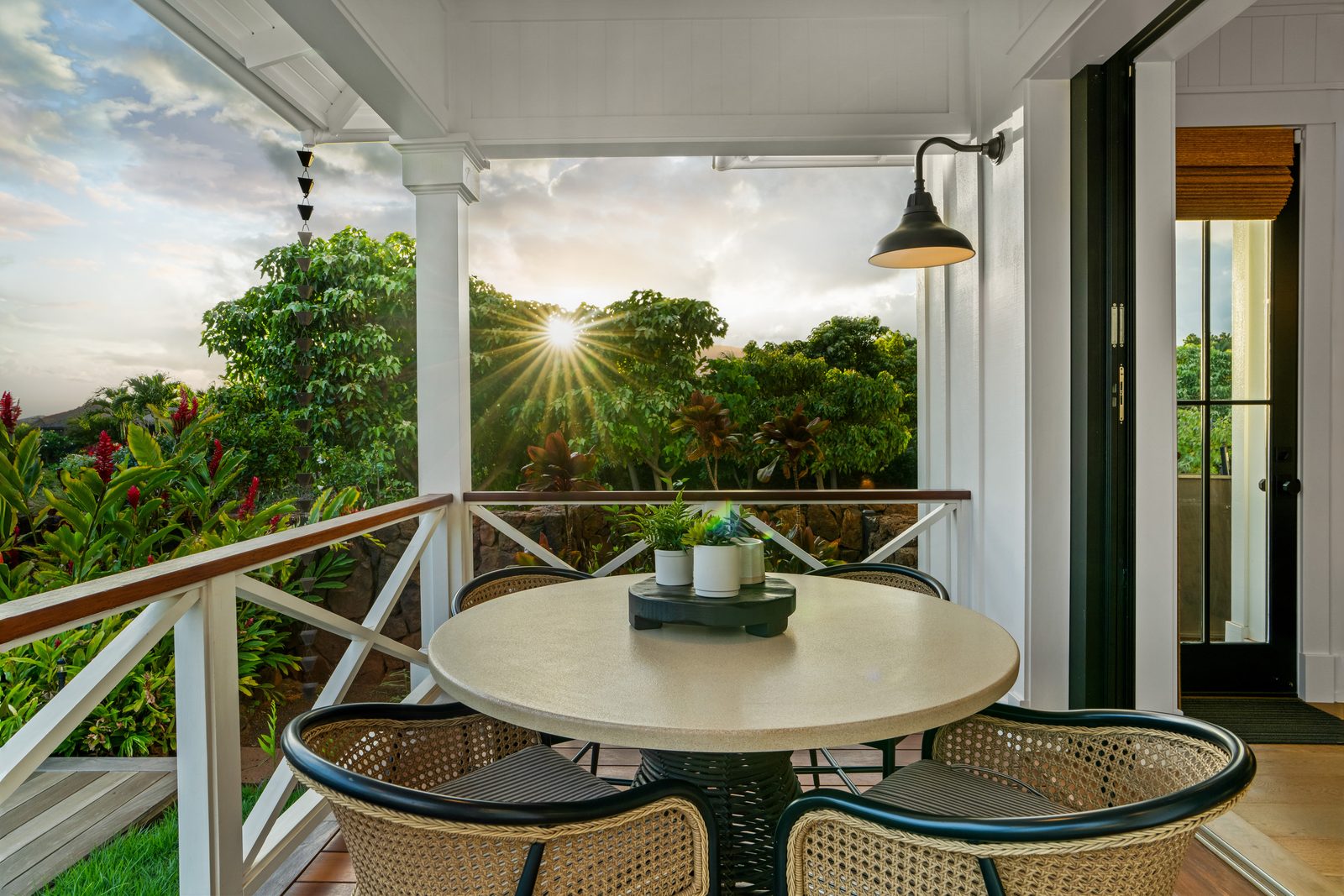 A lanai table at sunset, the sun starburst through the trees