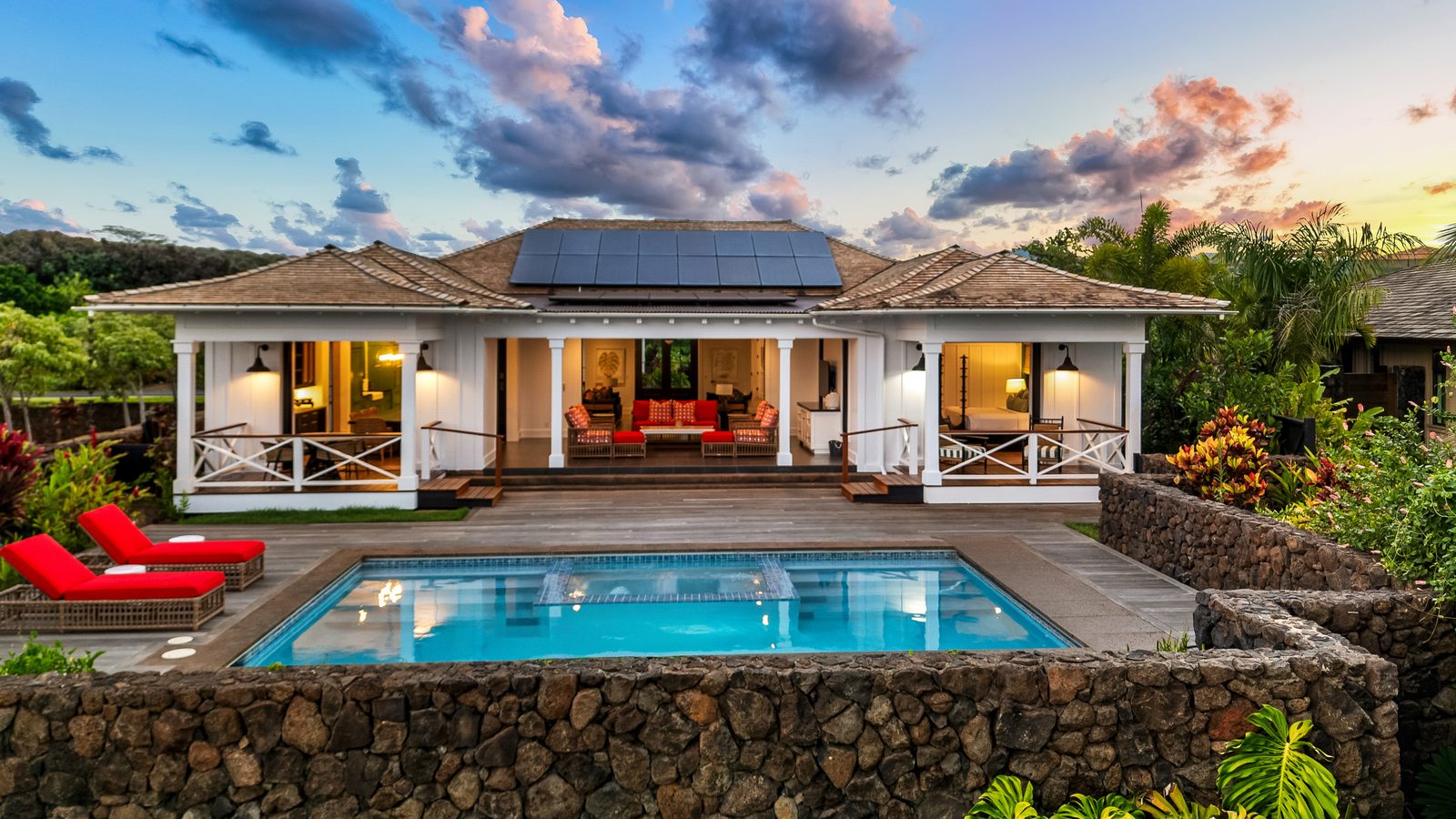 Hale Hikari at dusk: the lit house behind a private pool, under a pink and blue sky